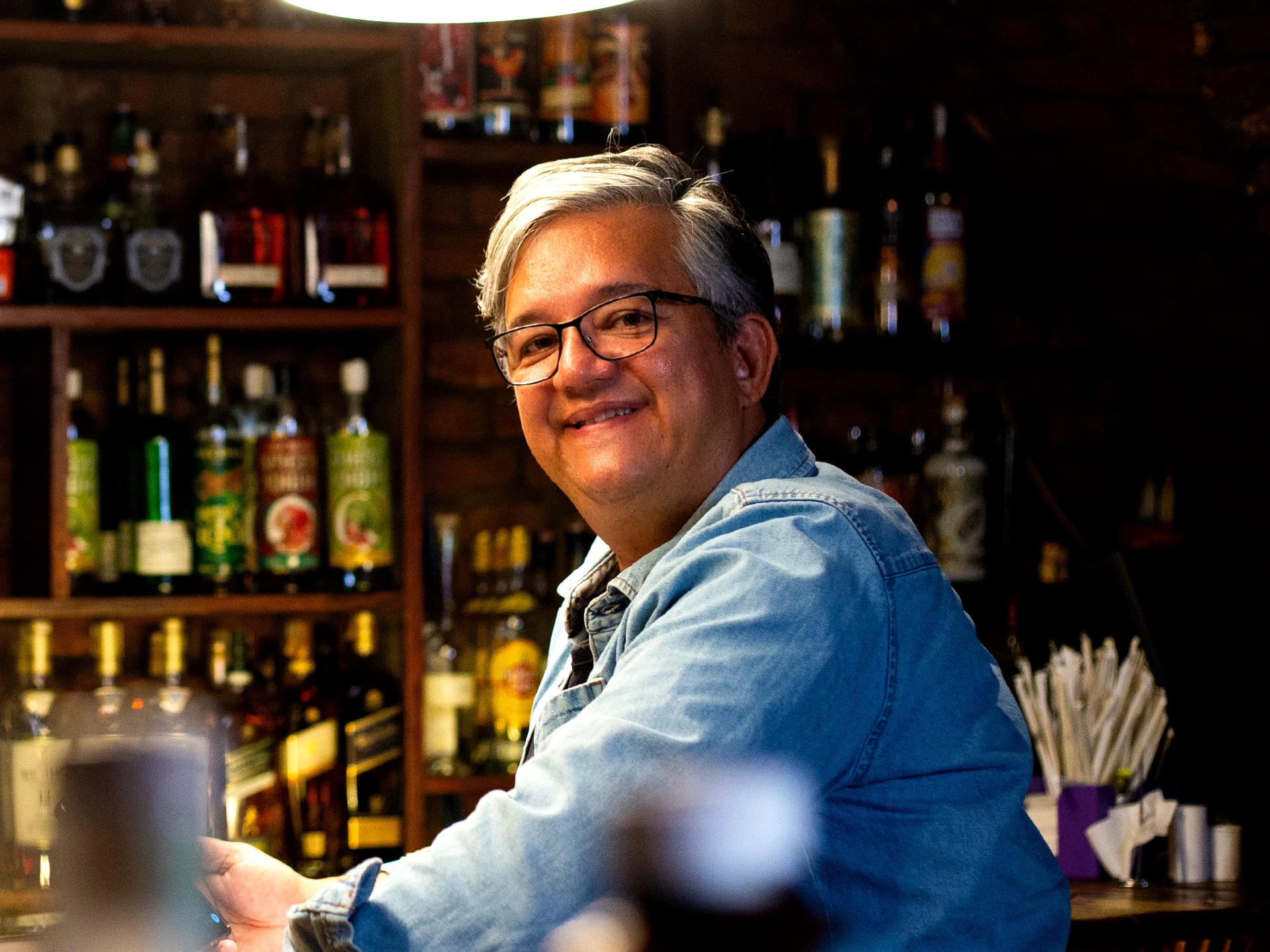Leopoldo Almeida, inventor and founder of Preshh, smiling behind a bar
