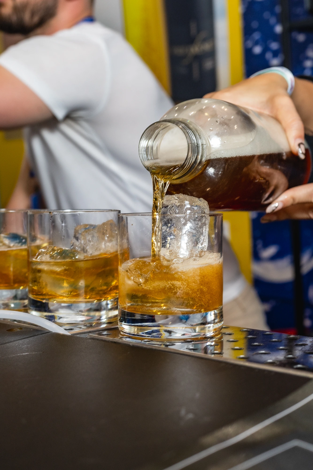 Bartender using the Preshh carbonation system on a vivid orange preparation