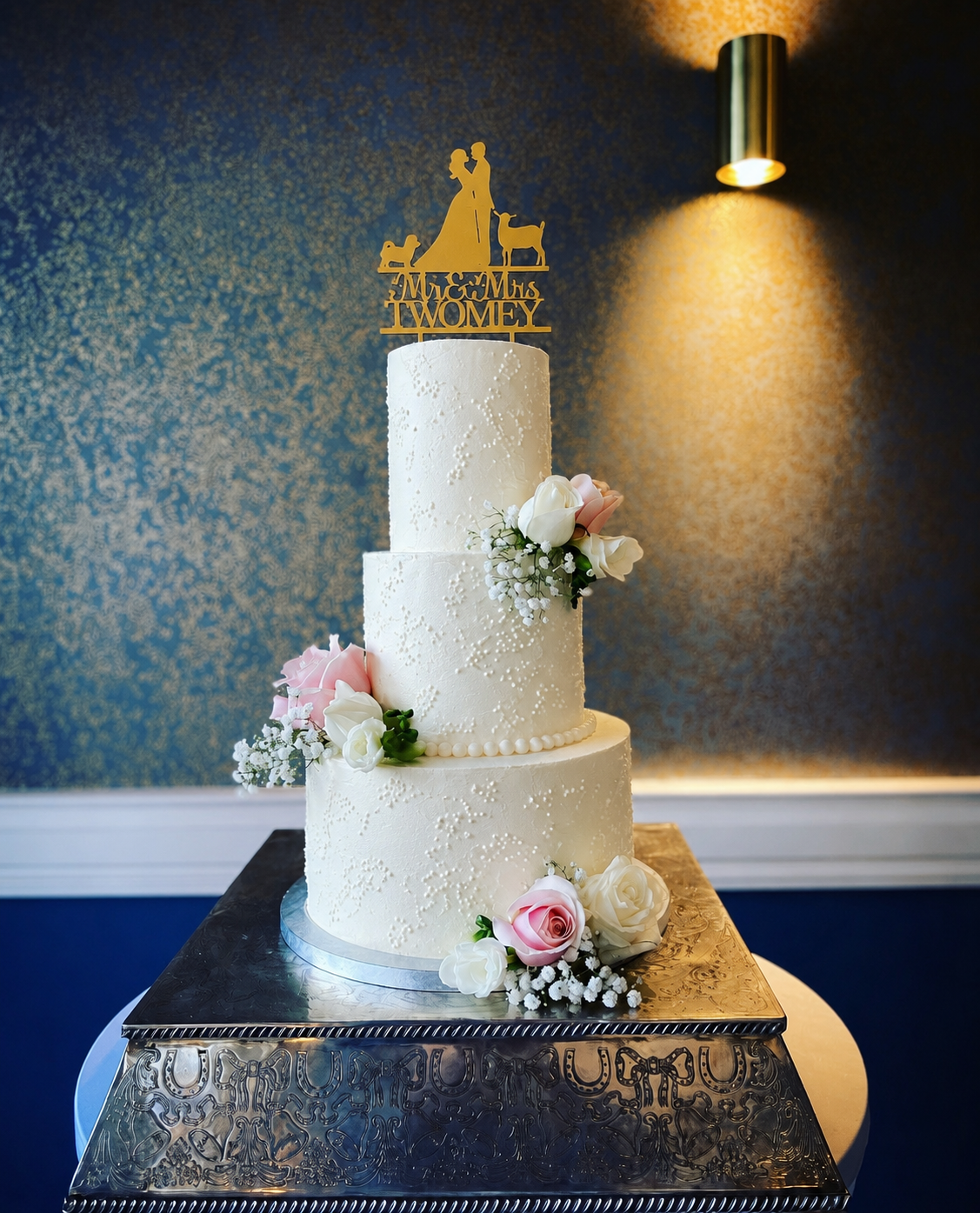 Three tier dummy wedding cake with pink and white roses and a personalised gold cake topper