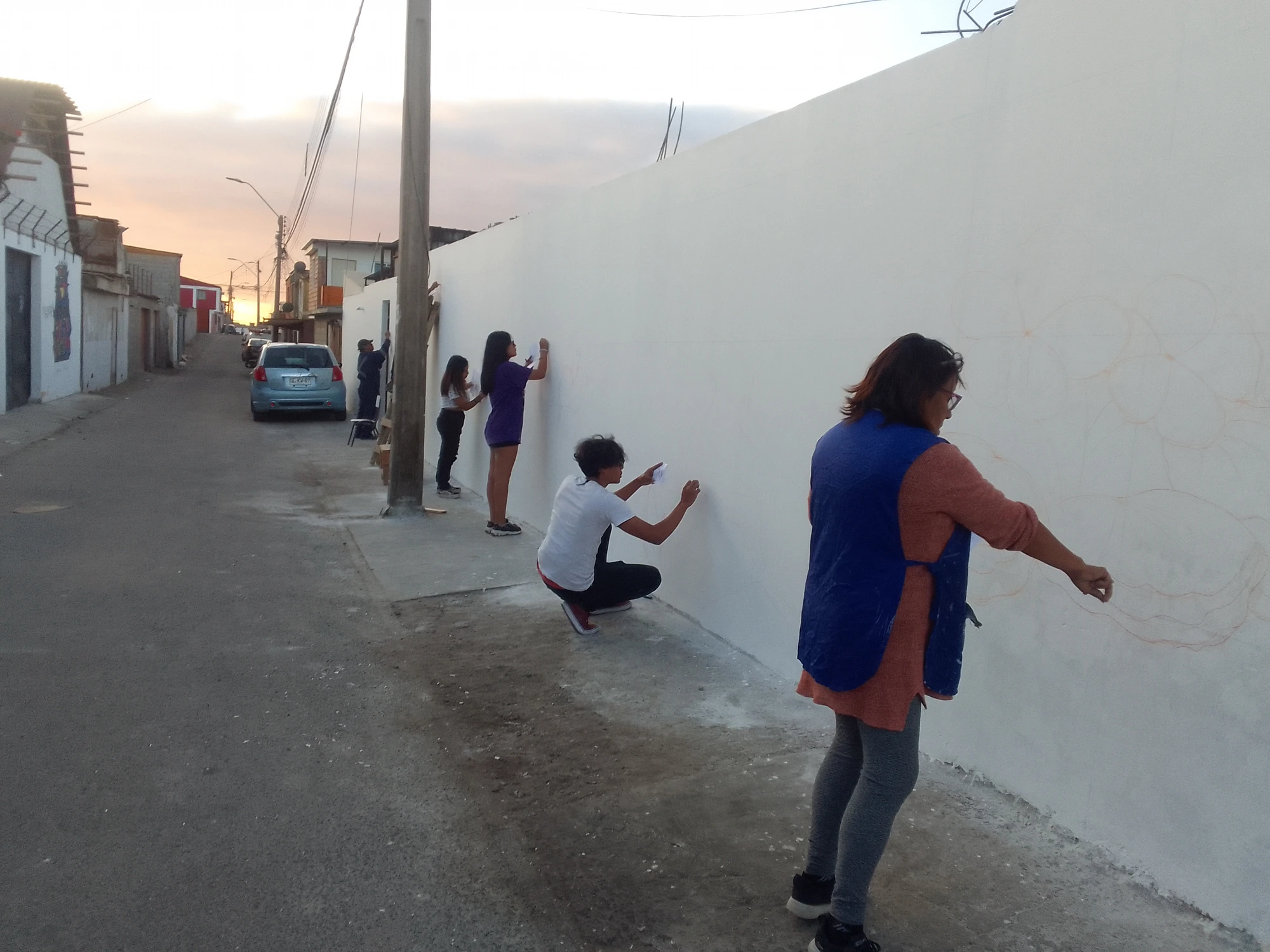 Il bozzetto riportato in scala sulla parete: al tramonto si tracciano le linee guida del murale.