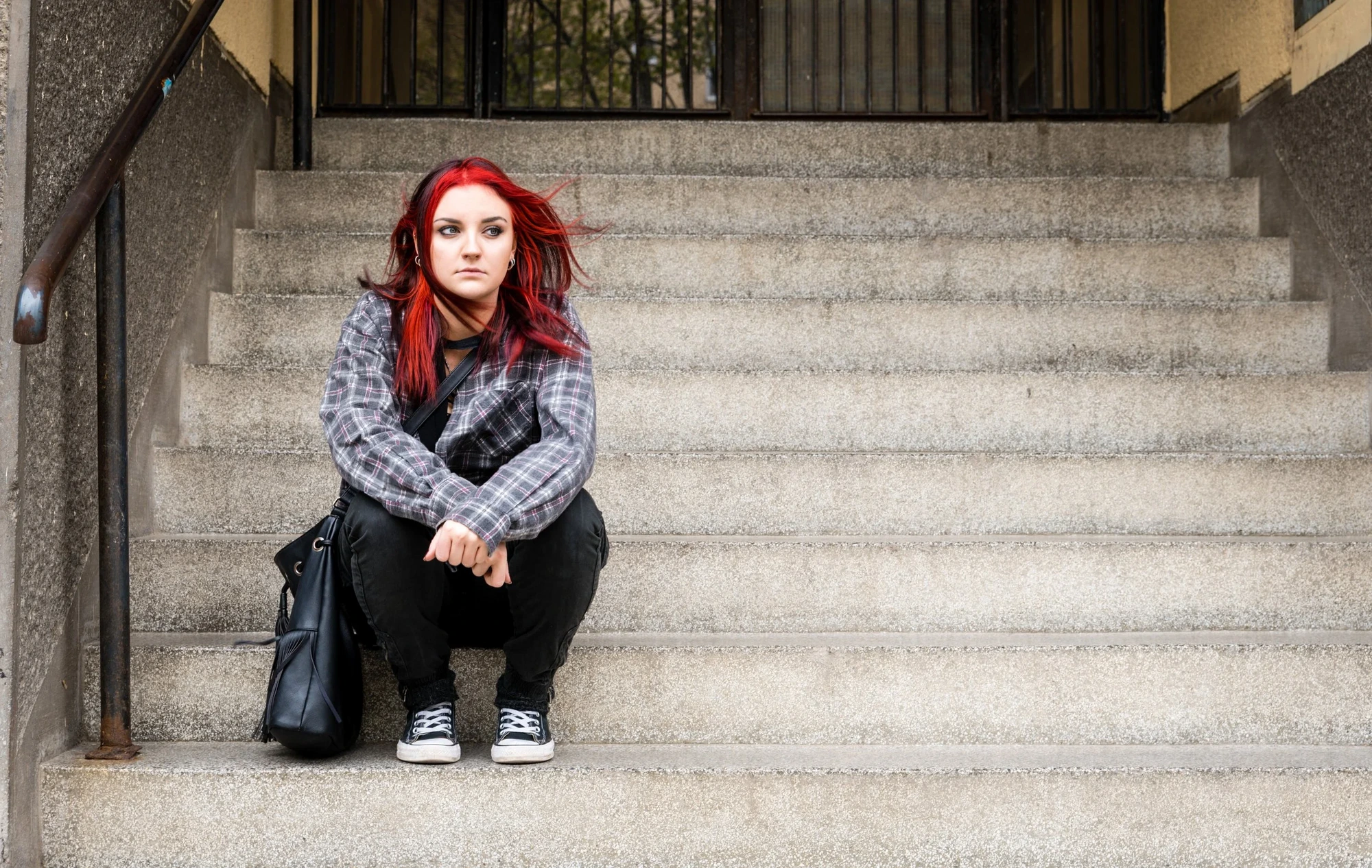 A student sitting on stone steps — the kind of face behind every campaign