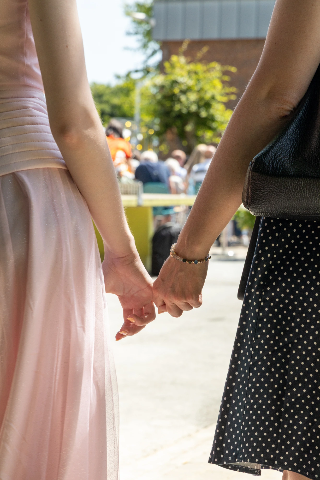 An aunt and her niece holding hands in the sun — the person who showed up