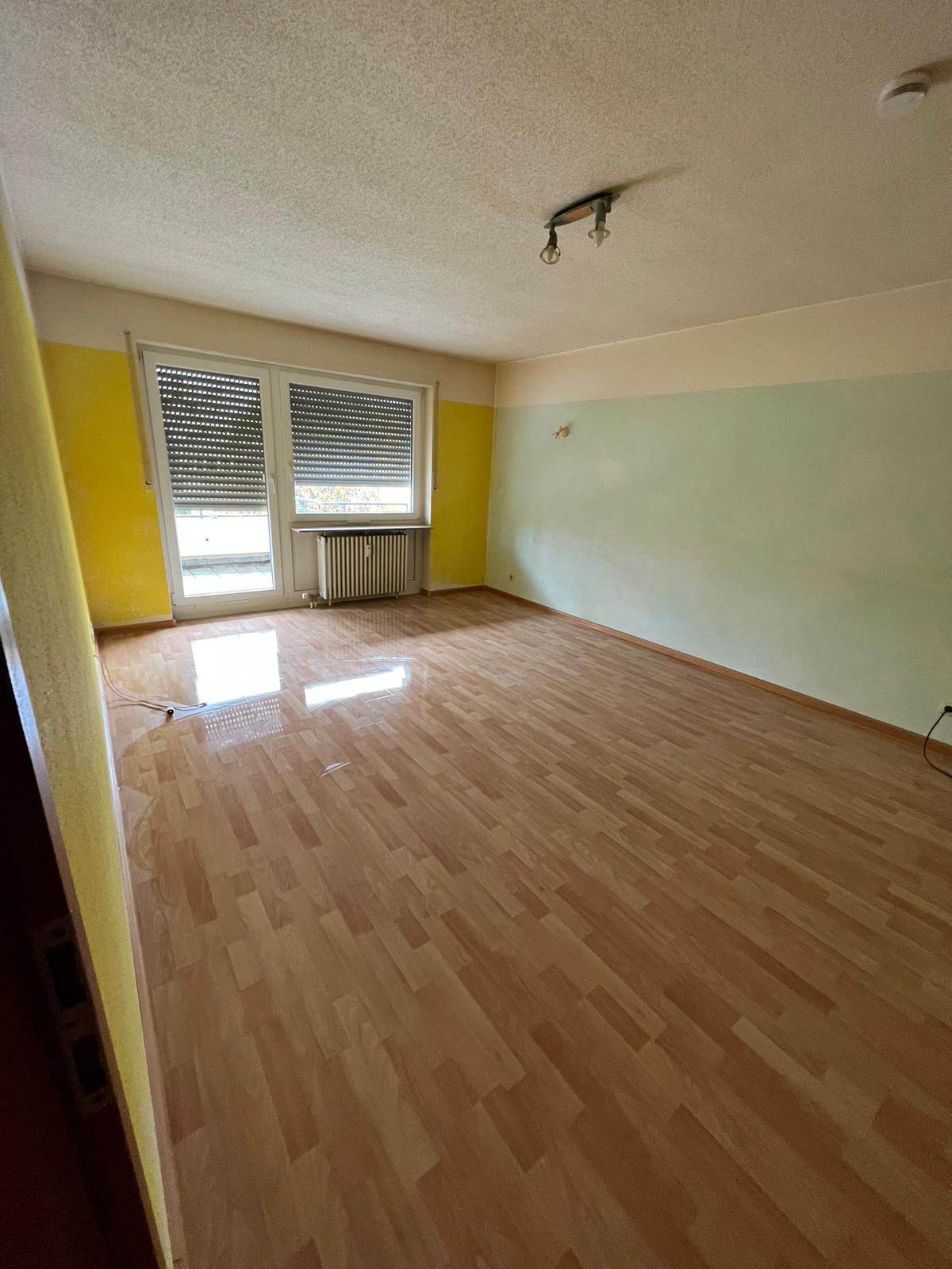 Leerer Raum mit Küche und Dachfenster nach einer Wohnungsräumung