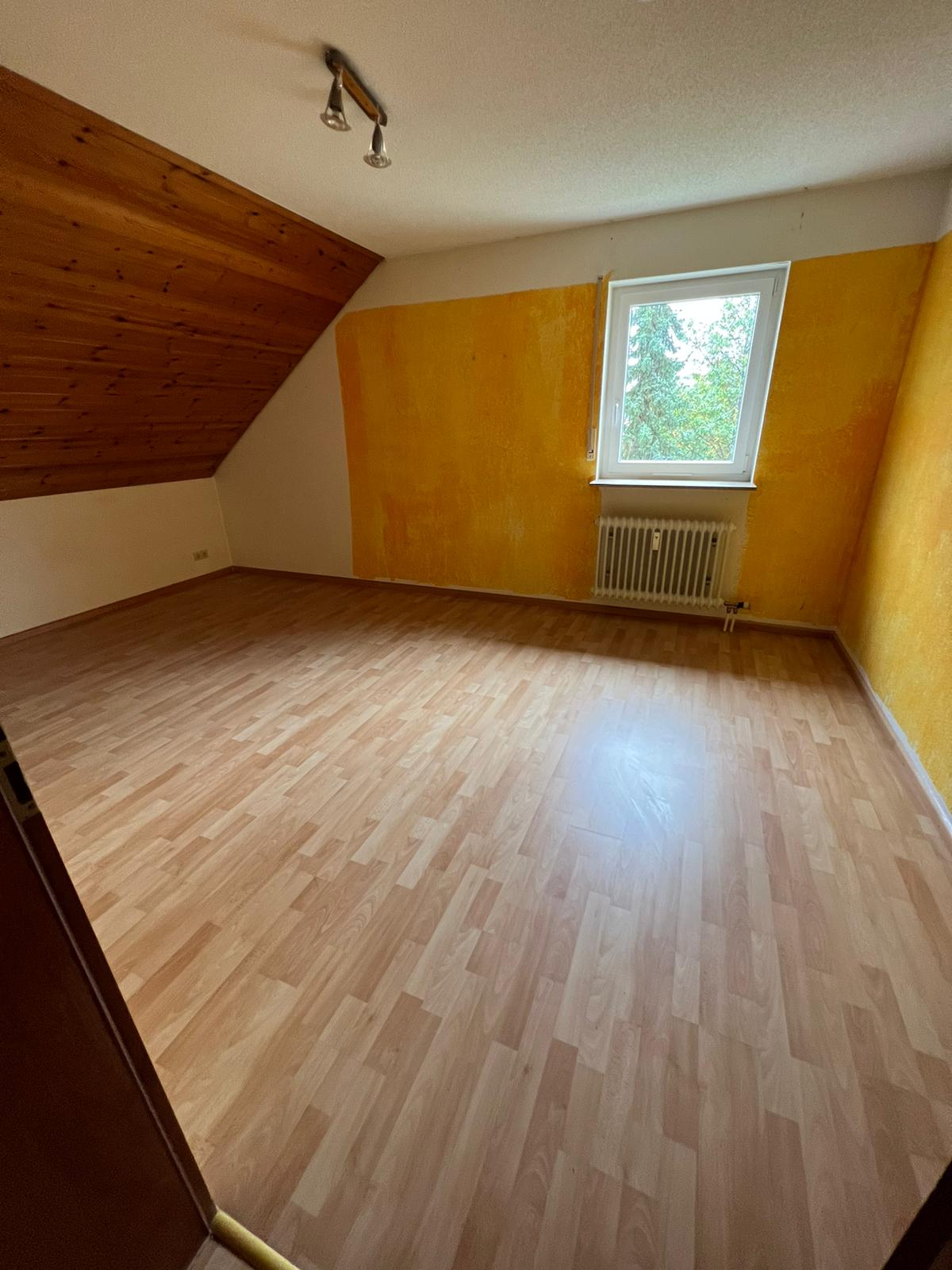 Leerer Wohnraum mit Fenster und Parkett nach dem Auszug