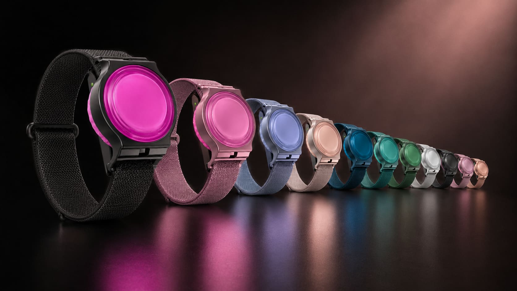A receding line of WearSpray wearable dispensers in a spectrum of colors on a dark reflective surface