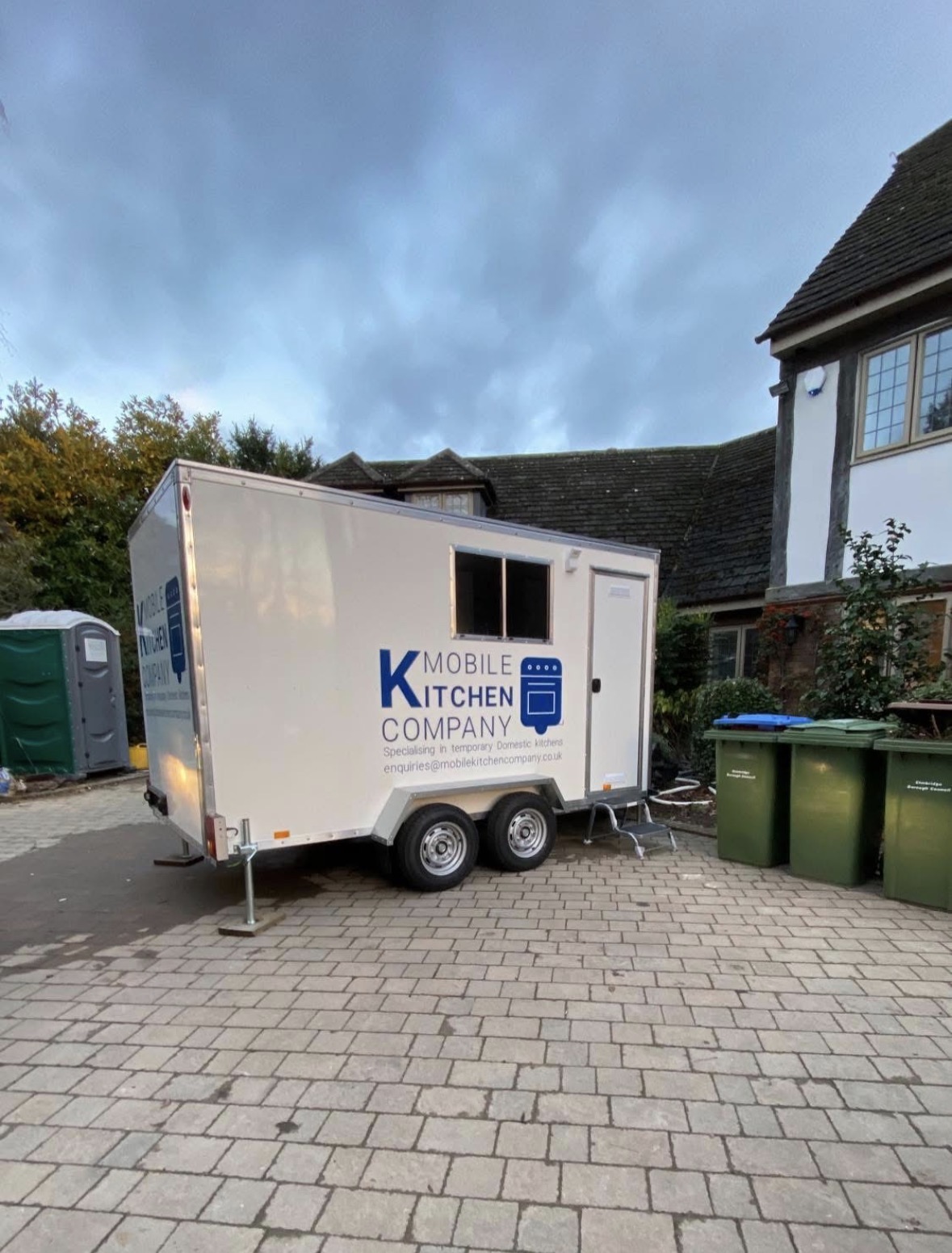 Mobile kitchen trailer parked on a residential driveway next to a house