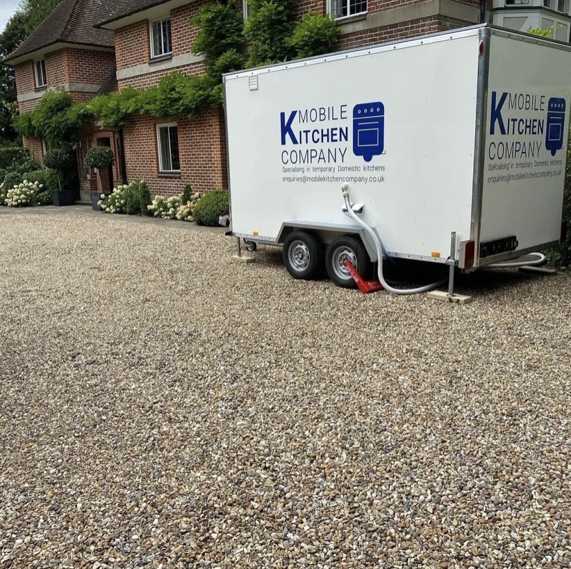 Temporary kitchen trailer parked compactly on a residential driveway