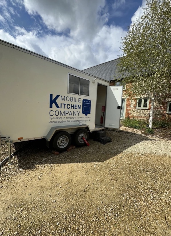 Temporary kitchen trailer with door open, ready to step in
