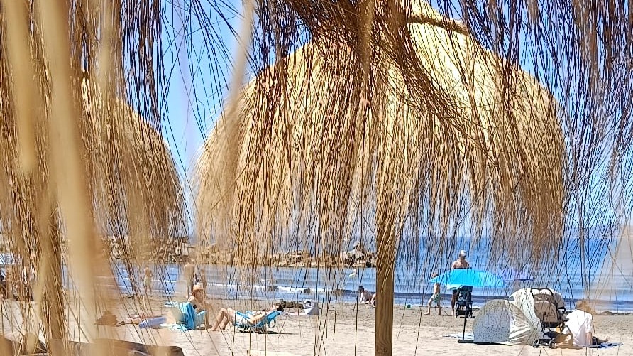 Beach club with thatched parasols at Playa del Cristo, Estepona